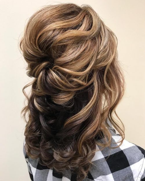 Long light brown hair styled in a half-updo with large, loose, voluminous curls.