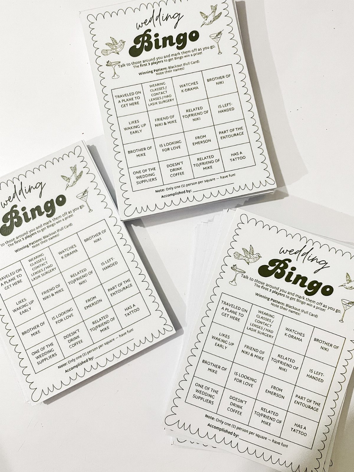 Three printed wedding bingo cards with green decorative borders and cocktail illustrations on a white background.